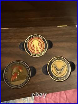 Three United States Air Force (USAF) challenge coins resting in A Wood Case
