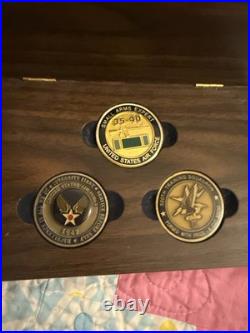Three United States Air Force (USAF) challenge coins resting in A Wood Case